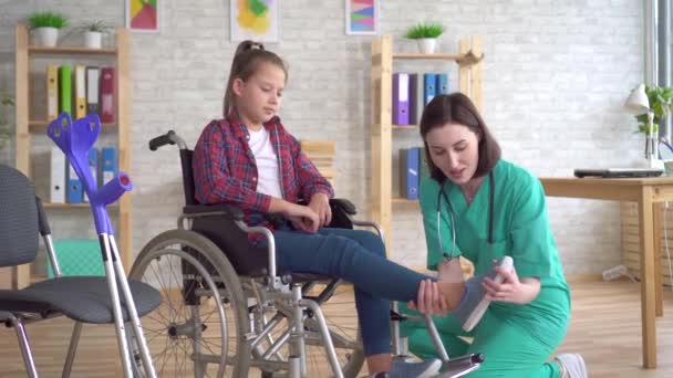 Teenage girl after an injury in a wheelchair at the reception of a doctor — Stock Video