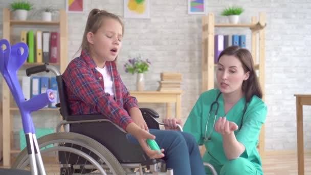 Девочка-подросток проходит реабилитацию у врача после травмы руки с помощью расширителя запястья — стоковое видео