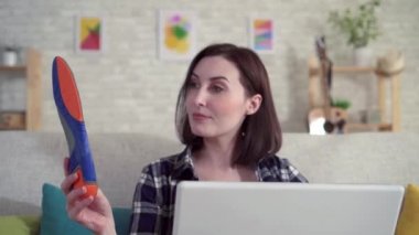 Genç kadın laptop kullanarak ve Ortopedi iç tabanlı hakkında bilgi için Internet arar