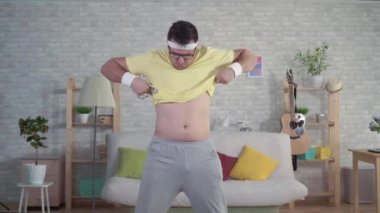 Sportwear expressive neşeli komik adam ölçüm bandı kullanır