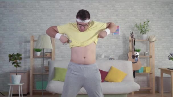 Expressieve vrolijke grappige man in Sportswear gebruikt meetlint — Stockvideo