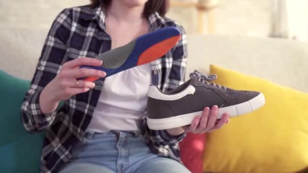 Young woman inserts an orthopedic insole into the shoe close up — Stock Video