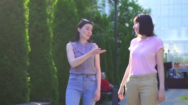 Two young beautiful women walking in the Park and communicate in sign language — Stock Video