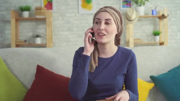 Positive young woman cancer patient after chemotherapy talking on the phone — Stock Video