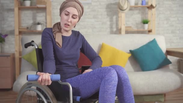 Junge Krebspatientin im Rollstuhl mit Schal in der Rehabilitation nach Chemotherapie aus nächster Nähe — Stockvideo