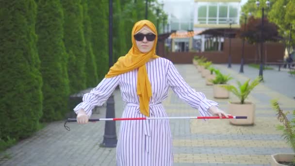 Retrato joven atractiva mujer musulmana con discapacidad visual con un bastón de caminar en el parque — Vídeos de Stock