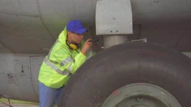 adam uzman havaalanında bir yolcu uçağının şasi teknik bir kontrol yapar