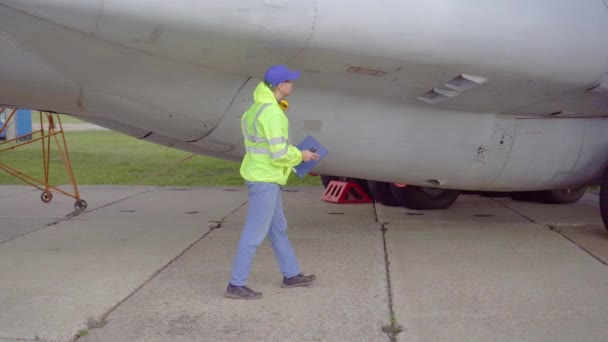 専門家は、空港で旅客機のシャーシの技術的なチェックを行います — ストック動画