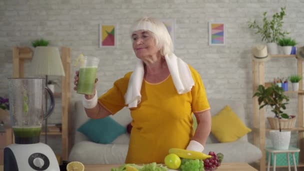 Ενεργή αθλητική ηλικιωμένη γυναίκα για να πιει ένα ρόφημα σέλινο, την έννοια της σωστής διατροφής και έναν υγιεινό τρόπο ζωής — Αρχείο Βίντεο