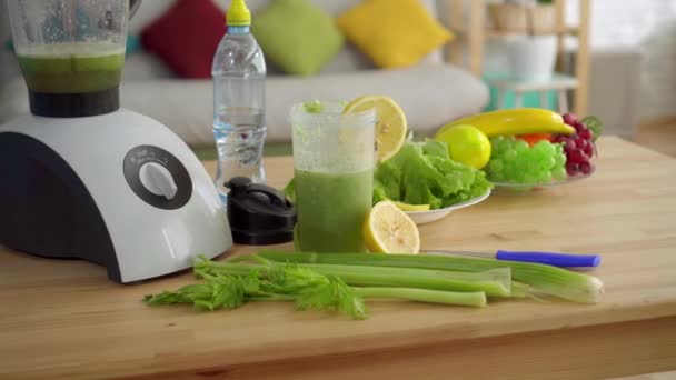 Concepto idea de nutrición adecuada, en la mesa batidos de apio, limones, ensalada, fruta y agua — Vídeos de Stock