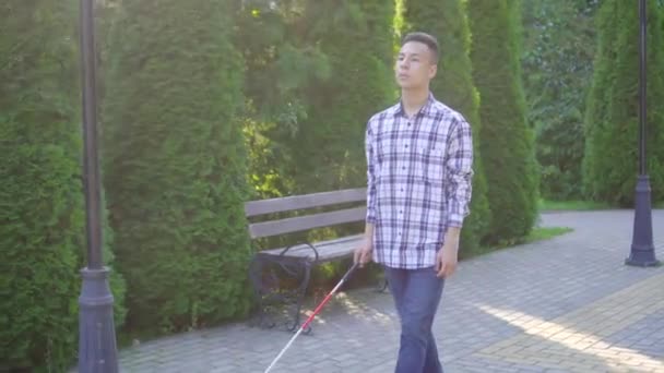 Giovane non vedente asiatico uomo con un bastone è nel parco — Video Stock