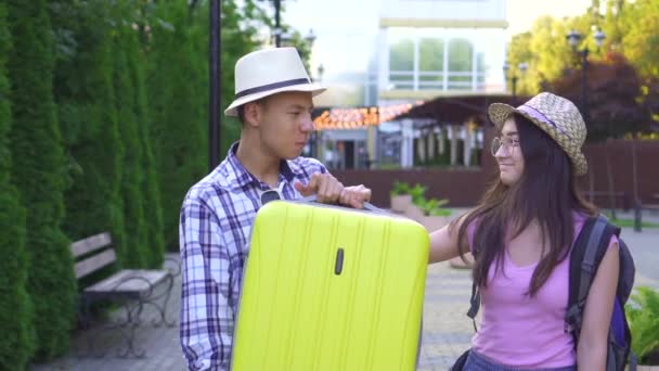 Porträt lächelnder asiatischer Touristen mit einem Koffer in der Hand — Stockvideo