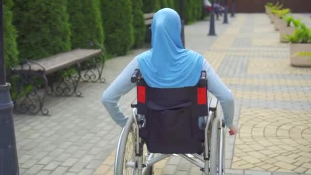 Jonge Arabische vrouw uitgeschakeld in traditionele sjaal in een rolstoel — Stockvideo