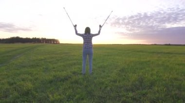 gün batımında bir alanda genç kadın koltuk değneği atar ve sevinç yavaş mo ellerini kaldırır