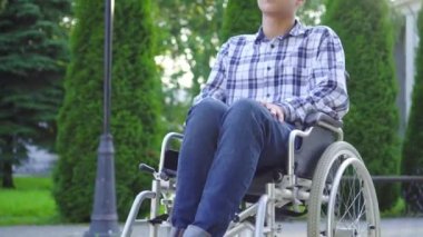 Portre genç Asyalı adam parkta tekerlekli sandalyede engelli