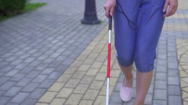 Bir baston ile genç görme engelli Asyalı kadın parkta yakın yavaş mo