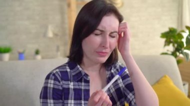 negatif gebelik testi tutan hayal kırıklığına üzgün genç kadın, adam onu sakinleştirir