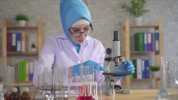 Mujer musulmana científica química en bufanda nacional trabajando en el laboratorio — Vídeo de stock