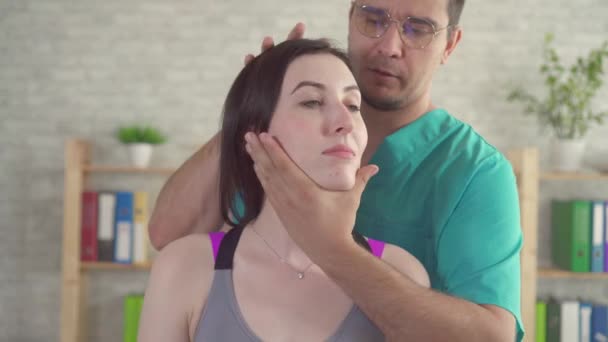 Mannelijke chiropactieen massage therapeut behandelt een jonge patiënt van nekpijn close-up — Stockvideo