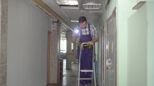 Homem de serviço homem em uma escada para inspecionar a ventilação — Vídeo de Stock