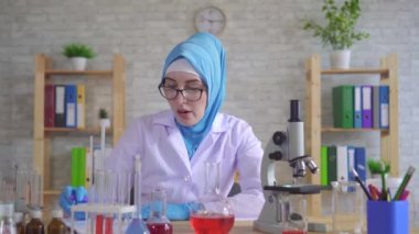 Yorgun genç müslüman kadın bilim adamı kimyager ulusal eşarp laboratuarda çalışıyor