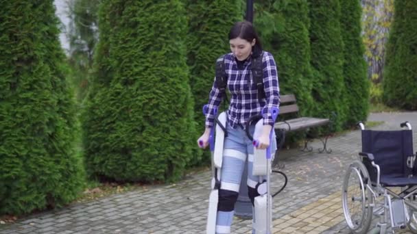 Mladá zdravotně postižená žena používá exoskeleton chodit v parku — Stock video