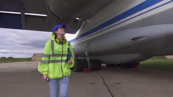 Női szakember szerelő elvégzi a műszaki ellenőrzést megy a repülőgép indulás előtt — Stock videók