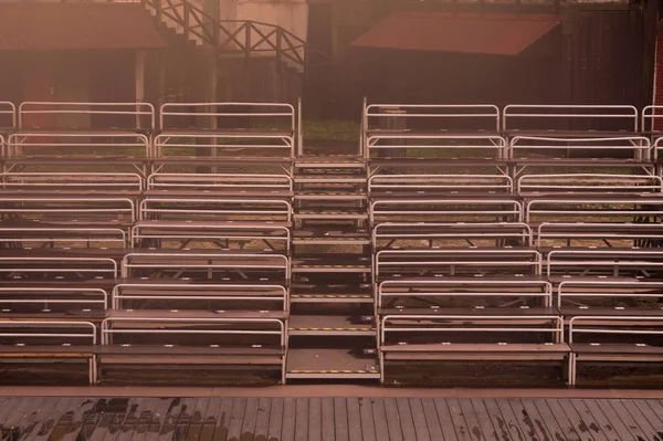 Empty benches on tribune with scene background — Stock Photo, Image