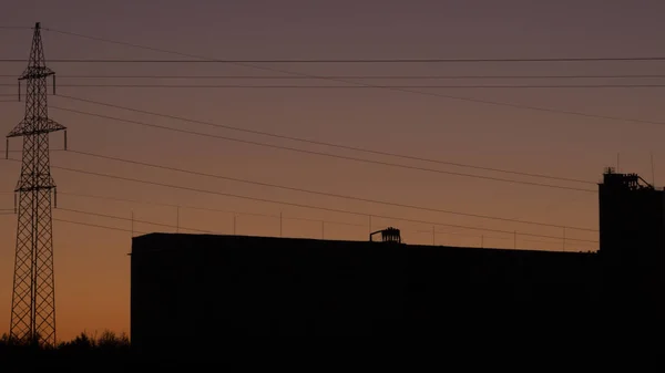 Tour haute tension avec silhouette ciel coucher de soleil fond — Photo