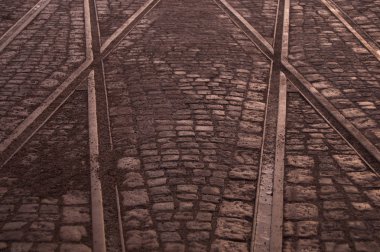 Şehir arka planda taş kaldırım üzerinde tramvay rayları geçişi