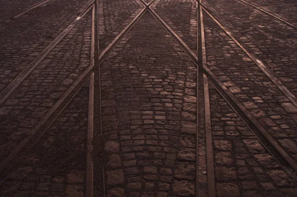 Cruzamento de trilhos de bonde no pavimento de pedra no fundo abstrato da cidade — Fotografia de Stock