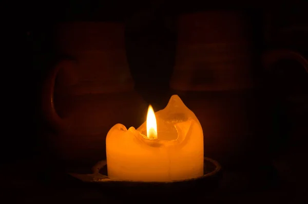 Κάψιμο κεριού στο σκοτάδι. κούπα στο τραπέζι. λαμπερή φλόγα — Φωτογραφία Αρχείου