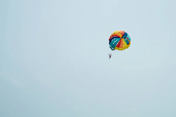 Skydiver που πετούν με ένα πολύχρωμο αλεξίπτωτο στο φόντο του ουρανού — Φωτογραφία Αρχείου