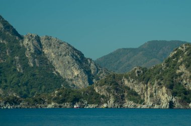 Bir dağın kıyısına yakın teknede rekreasyon. Suya gemi. yaz tatil seyahat