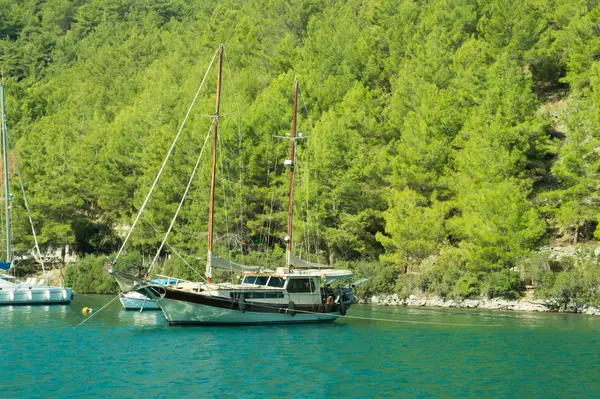 山と森の海岸近くのボートでのレクリエーション。湾に船。夏休み旅行 — ストック写真