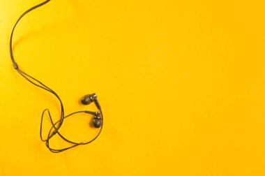 Sarı arka planda kulaklıklar. Minimalizm