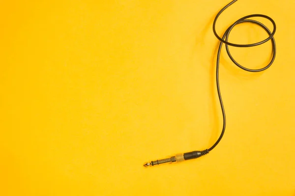 Conector de audio con cable negro aislado en amarillo —  Fotos de Stock