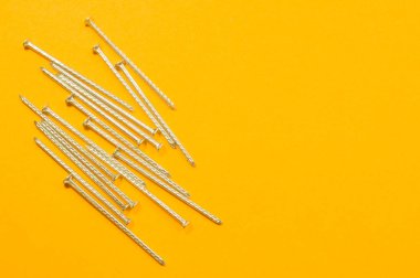 Sarı arka planda izole metal çivi. çalışma araçları