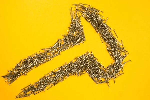 Sarı arka planda izole metal çivi. çalışma araçları