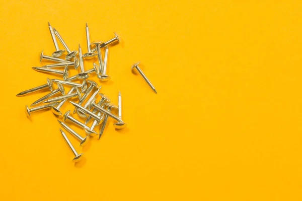 Clavos de metal aislados sobre fondo amarillo. herramientas de trabajo — Foto de Stock