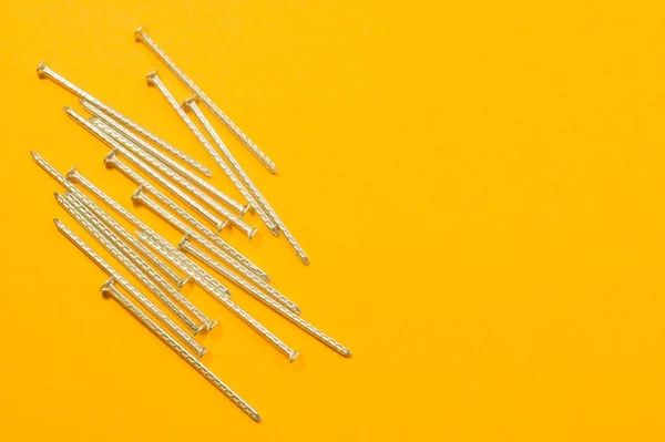 Clavos de metal aislados sobre fondo amarillo. herramientas de trabajo — Foto de Stock