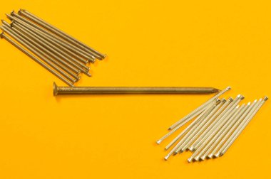 Sarı arka planda izole metal çivi. çalışma araçları