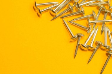 Sarı arka planda izole metal çivi. çalışma araçları