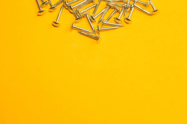 Clavos de metal aislados sobre fondo amarillo. herramientas de trabajo — Foto de Stock