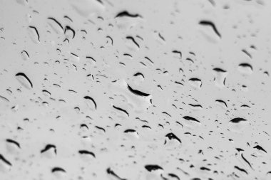 Pencerede yağmur damlaları var. Cam makronun üzerine yağmur damlaları. Su damlaları pencereye düşüyor. Yağmurlu gün