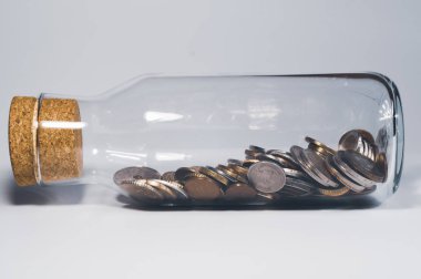 Mantar durdurucu ile Cam kavanoz ve çeşitli ülkelerden uluslararası sikke ile dolu. finans depolama konsepti