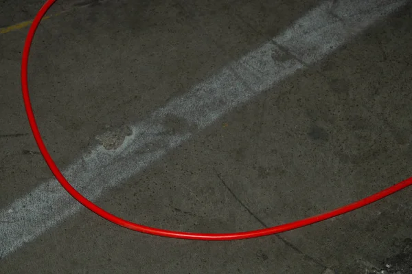 Red electric power cable. red wire lies on the ground. mess on cement floor