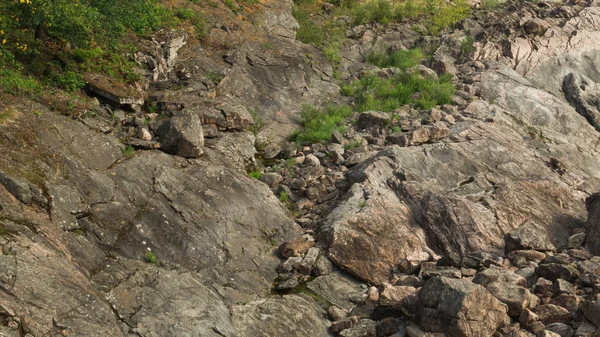 Rocha de pedra em camadas coberto com grama e musgo. textura de pedras rochas — Fotografia de Stock