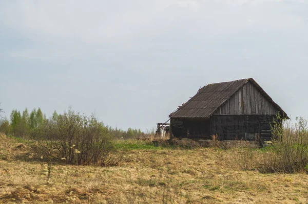 Старий дерев'яний будинок у сільській місцевості. будинок стоїть сам у полі — стокове фото