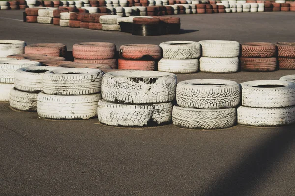 Race track safety barrier. asphalt racing track with red and white tires. colorful tires stack. karting racetrack